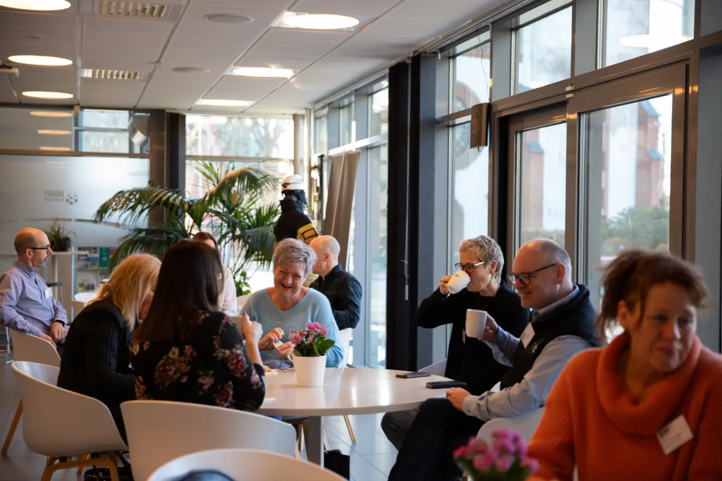 människor i grupp sitter och samtalar med varandra