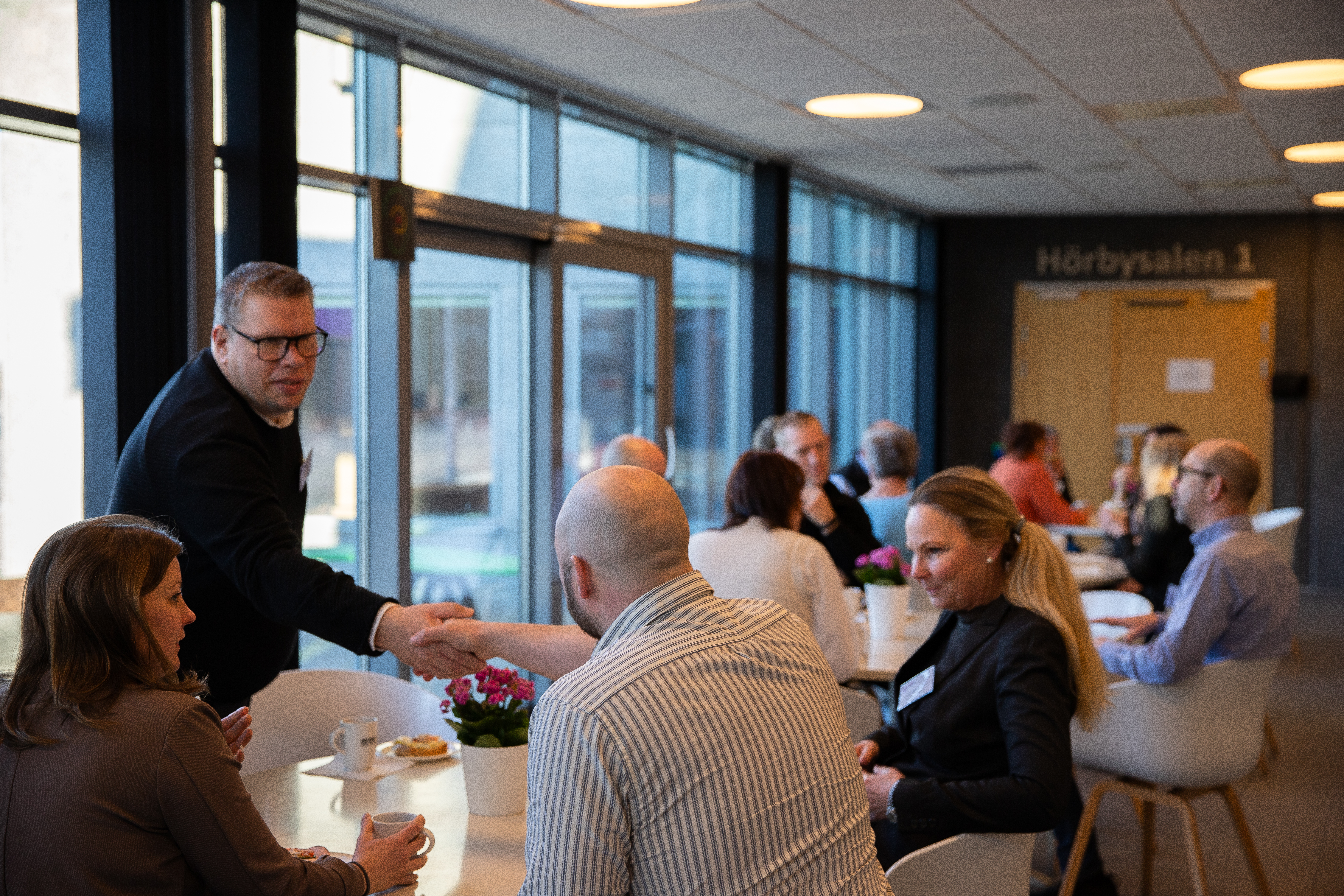 människor i grupp sitter och samtalar med varandra