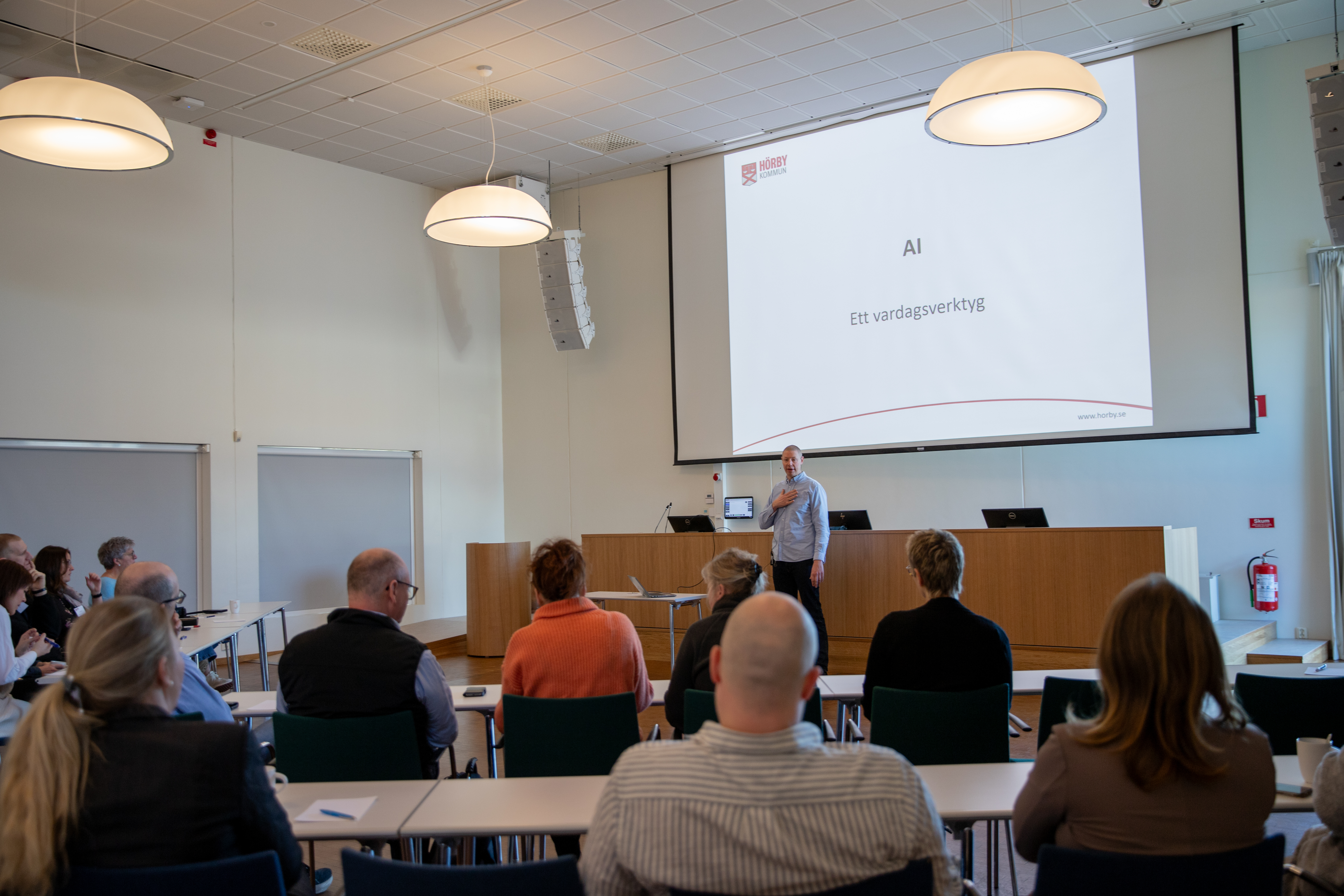 man står och pratar framför en grupp av människor i ens tor dal.