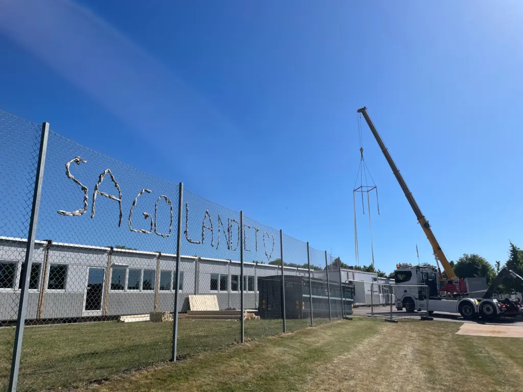 Lyftkran i färd med att lyfta bort husmoduler.