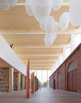 Illustration på nya Kulturhuset invändigt. Till vänster syns hyllor med böcker och till höger syns fasaden till biograf Metropol.