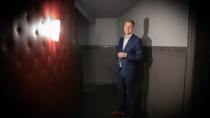 person står och poserar vid vägg
