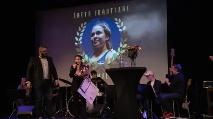 Två personer står på scen och pratar i mikrofon på en prisutdelning