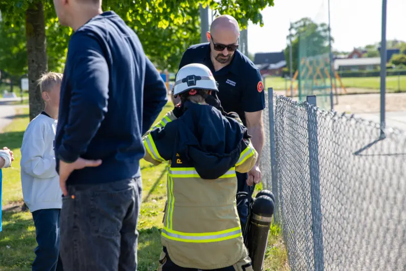 vuxen person hjälper ett barn att prova räddningsutrustning.