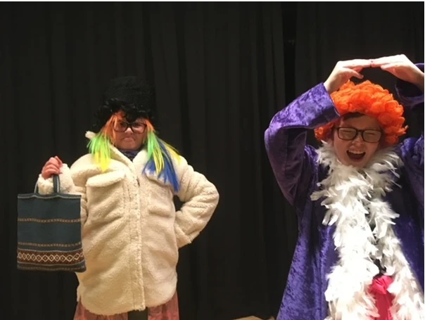 två utklädda barn står och poserar mot en mörk bakgrund