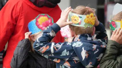 Två barn med papperskransar runt huvudet
