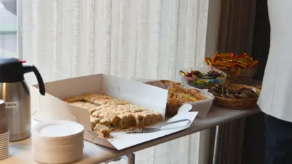 En förpackning med morotskakor bredvid skålar med wienerbröd och godis