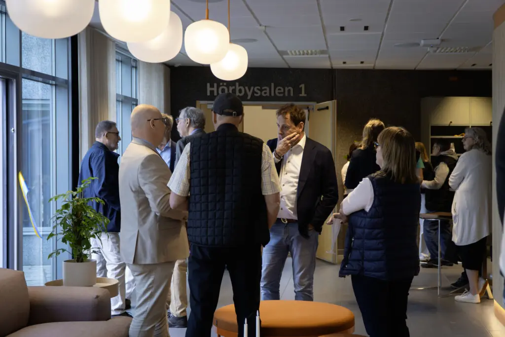 I ett upplyst kontaktcenter står en samling människor och pratar