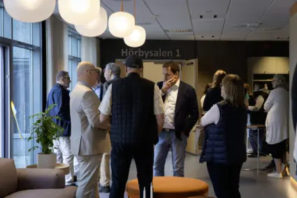 I ett upplyst kontaktcenter står en samling människor och pratar
