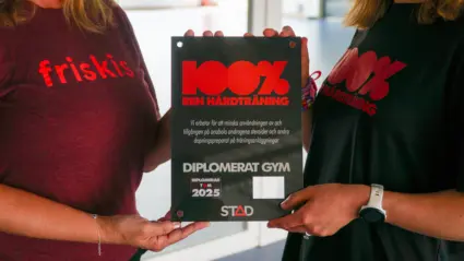 Ett svart diplomplakat med rubriken 100% ren hårdträning. Texten på plakatet beskriver att gymmet nu är diplomerat enligt 100% ren hårdtränings-metoden