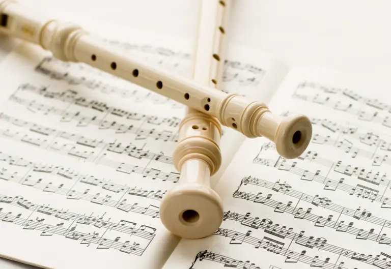 två blockflöjtar ligger korsade över ett notblad