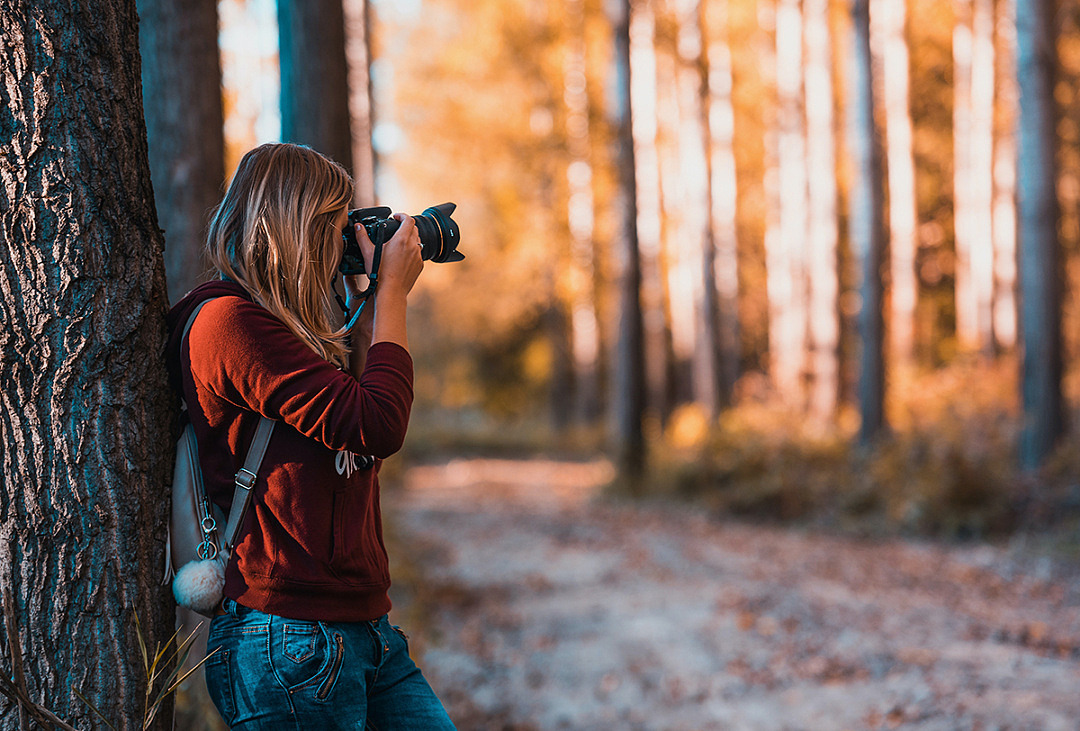 Kvinna fotograferar i naturen.