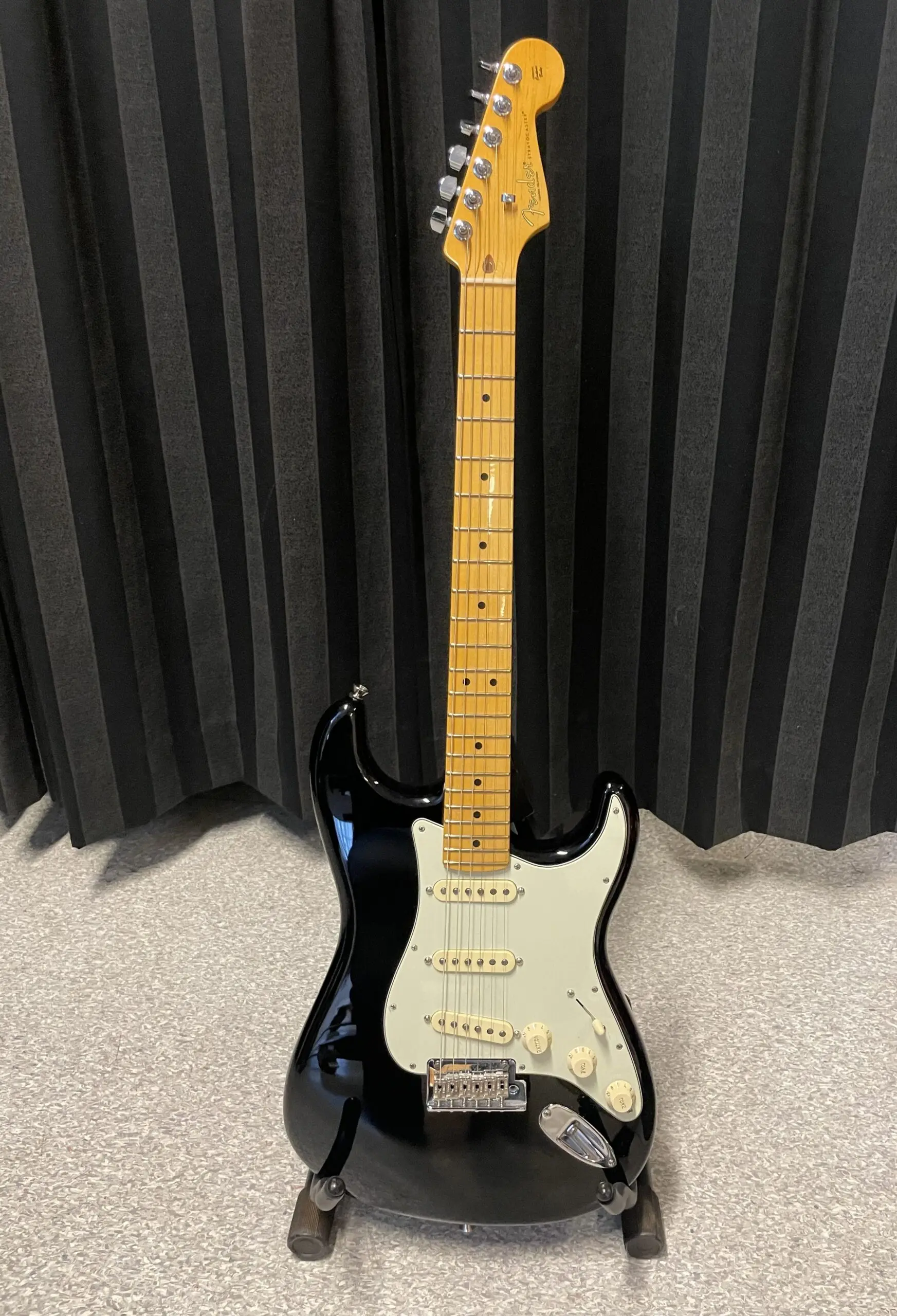 elgitarr ståendes mot ett svart draperi