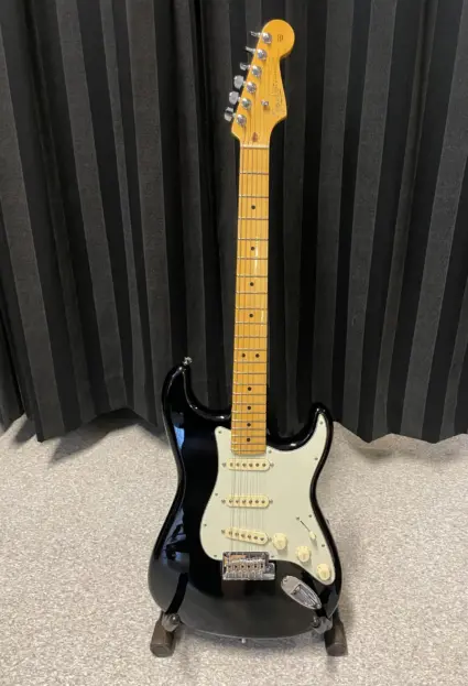 elgitarr ståendes mot ett svart draperi