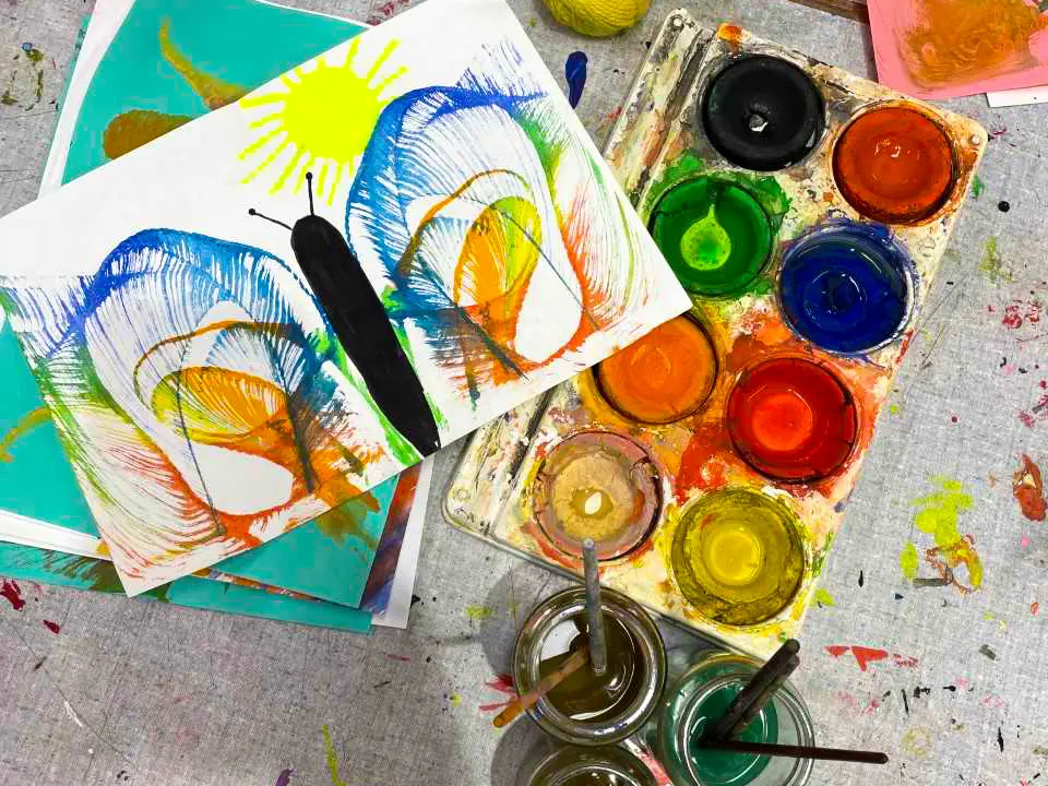 En förpackning med vattenfärg bredvid en teckning av en fjäril