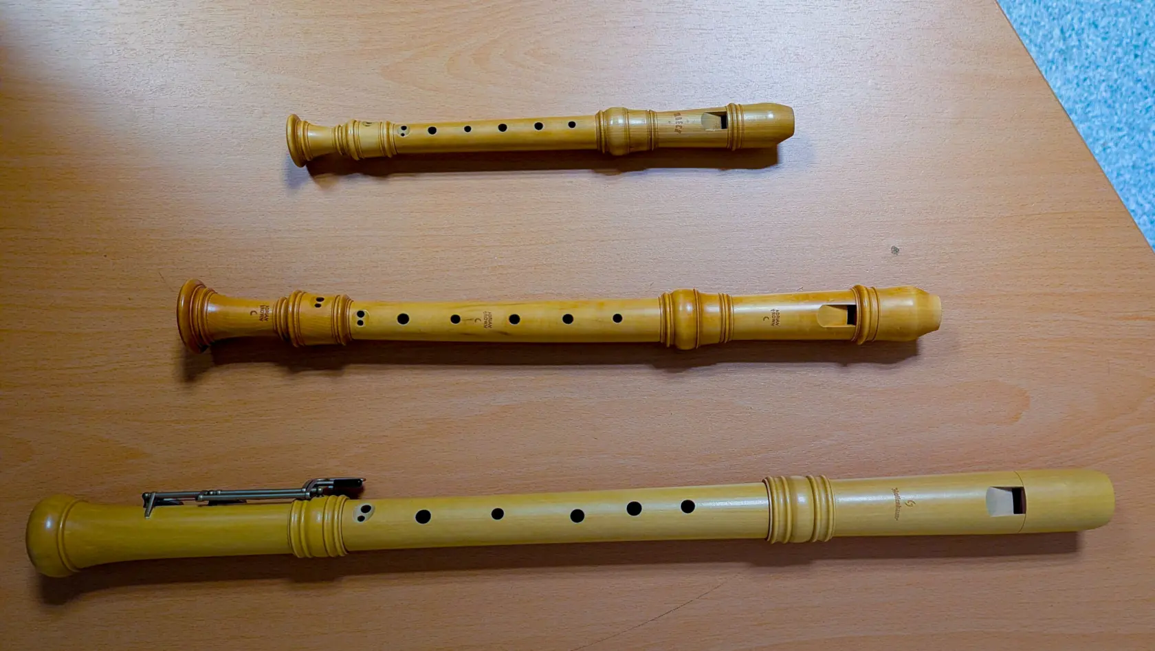 Tre olika blockflöjter ligger på ett bord