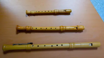 Tre olika blockflöjter ligger på ett bord