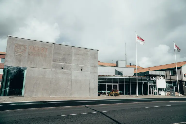 Två hissade kommunflaggor framför entrén till Hörby kommunhus.