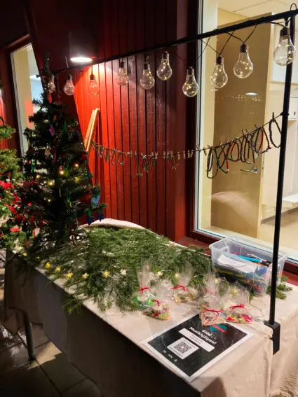 Ett bord täckt med granris och en swish-lapp till Musikhjälpen.