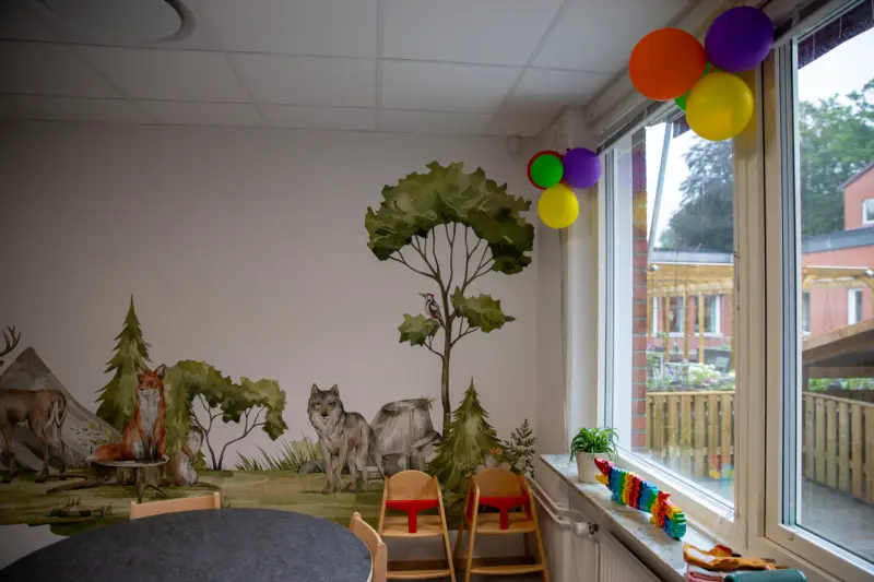 lokal med tapetbekl&auml;dd v&auml;gg som f&ouml;rest&auml;ller en skog med djur.