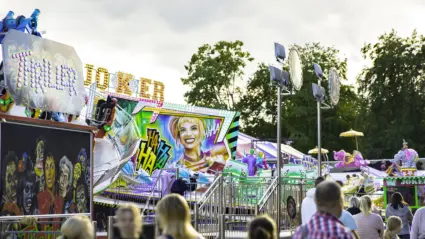 Parktorget med tivoli i vacker kvällsol och kraftiga färger.