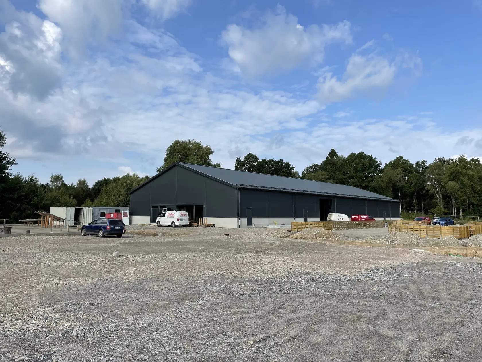 Svart hall omgiven av grus och arbetsfordon.