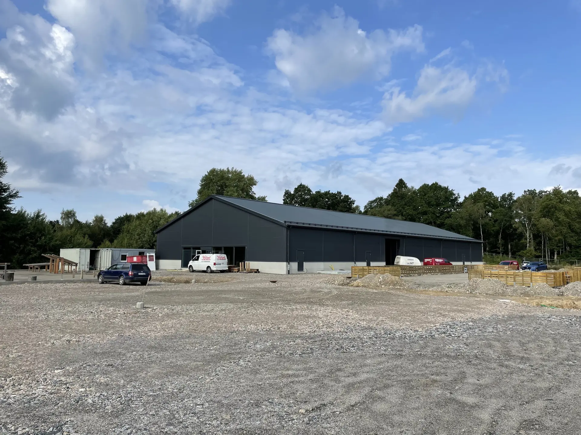 Svart hall omgiven av grus och arbetsfordon.