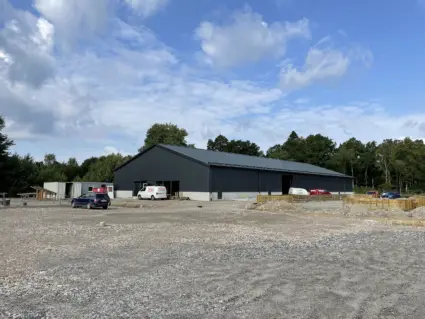 Svart hall omgiven av grus och arbetsfordon.