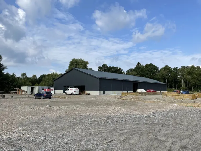 Svart hall omgiven av grus och arbetsfordon.