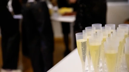 Närbild på rader av plastglas med ljus cider i