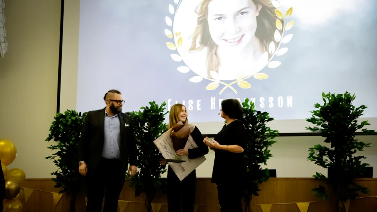 Flicka i tonårsåldern tar emot stipendium på scenen.