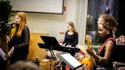 Bild på bandet snett bakifrån. Gitarristen i fokus.