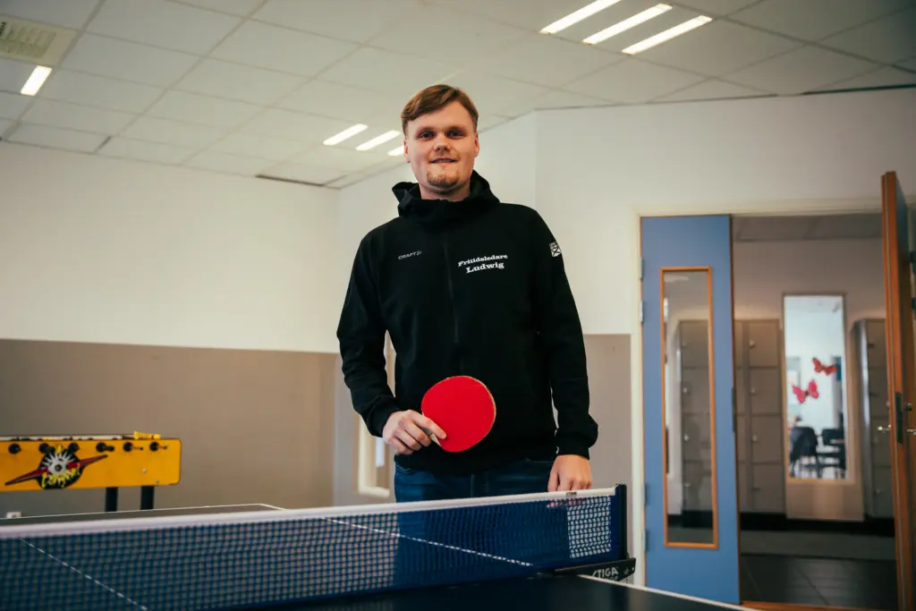 Man som står med pingisrack i handen
