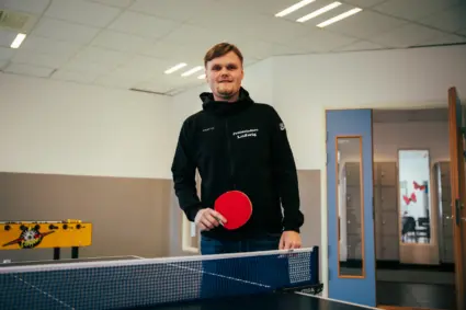 Man som står med pingisrack i handen