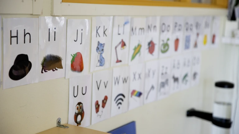Närbild på bokstäver som hänger på en vägg i förskola