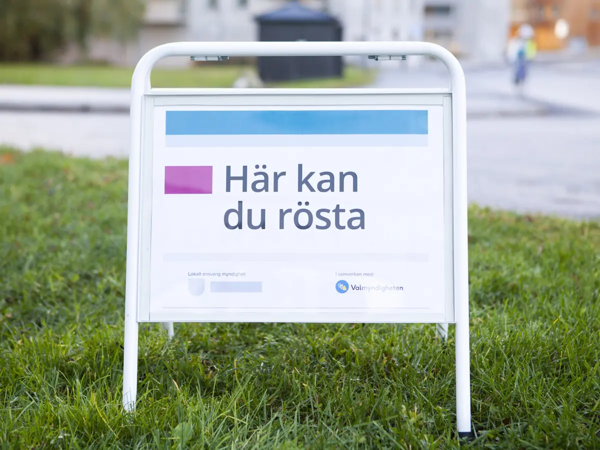 Skylt som står på gräsmatta, budskapet på skylten lyder "Här kan du rösta"