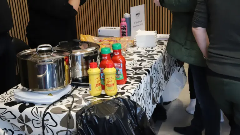Närbild på station där det delas ut korv med bröd