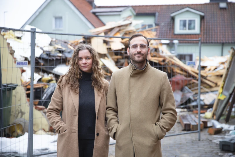 Projektledarna, en ung kvinna och en ung man, står framför rasmassor.