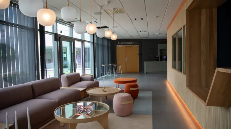 Vy över tomt kontaktcenter, med soffgrupp till vänster och reception till höger.
