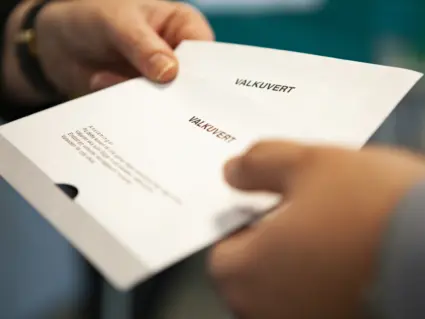 Händer som håller i kuvert.