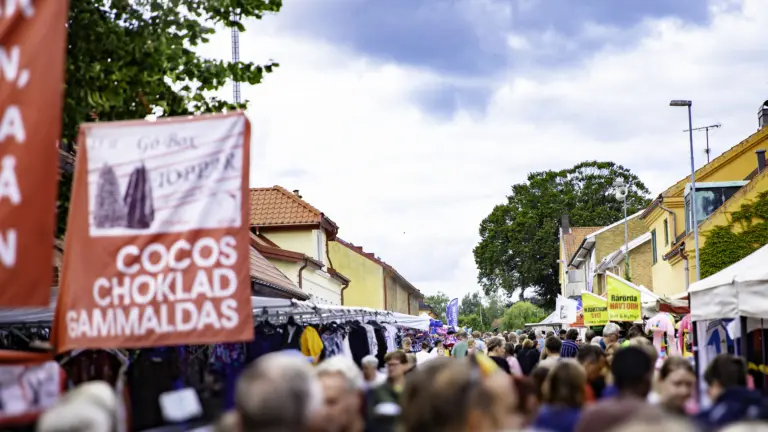 Folkvimmel under marknaden, med marknadsstånd på båda sidorna
