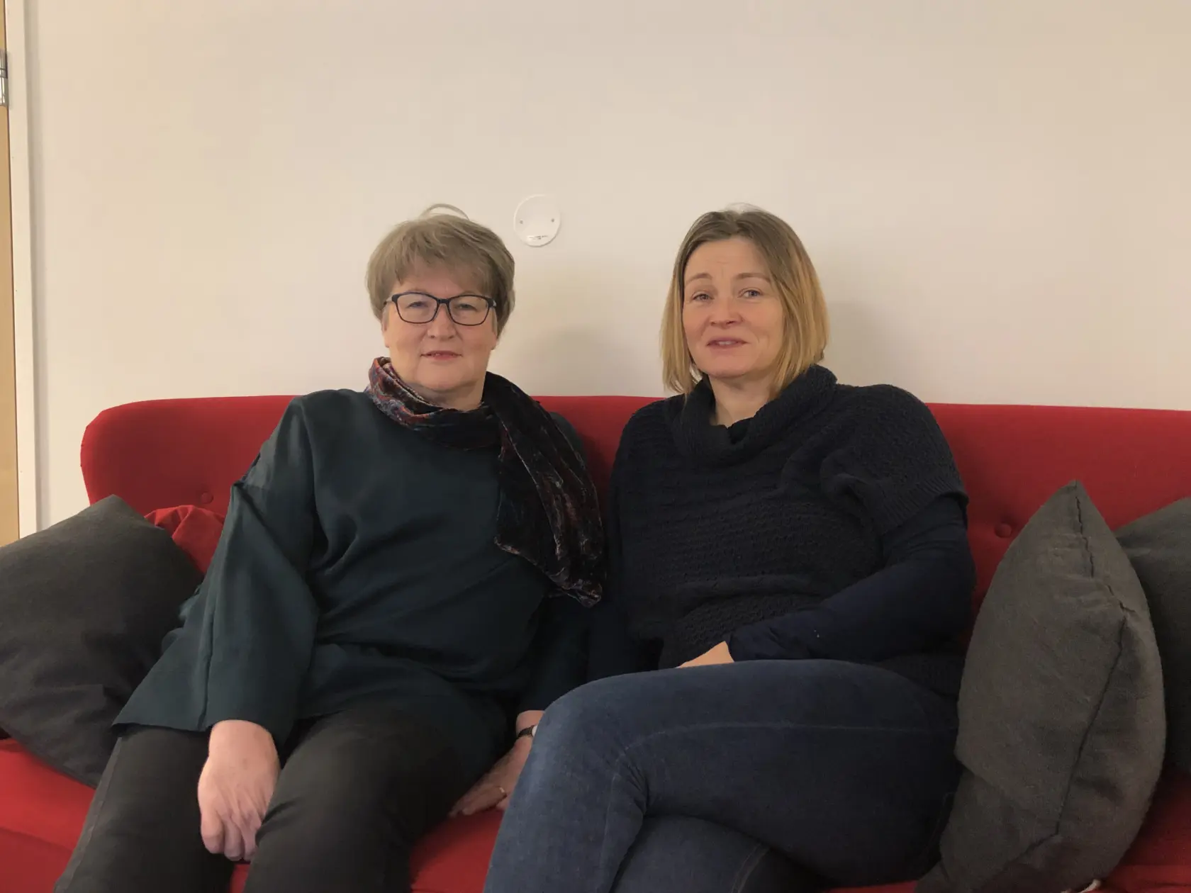 Två kvinnor i röd soffa