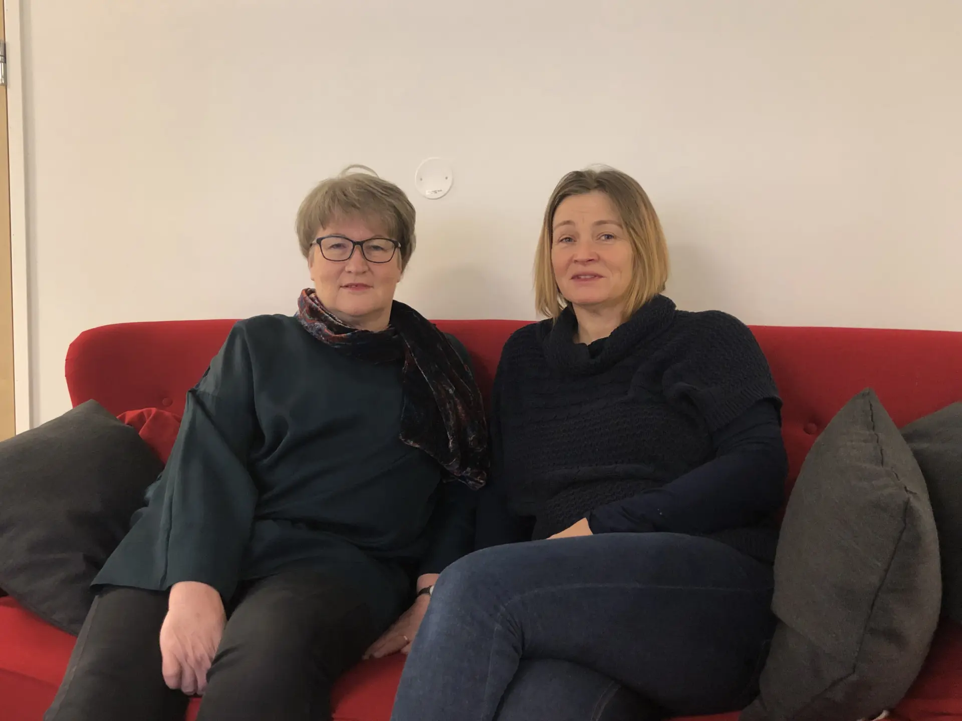 Två kvinnor i röd soffa