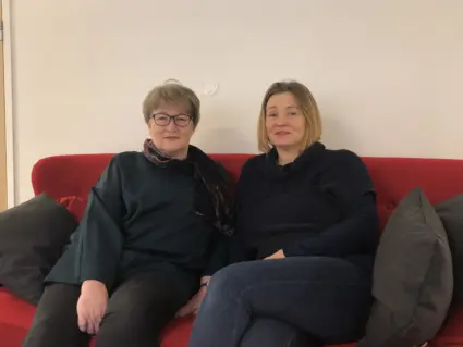Två kvinnor i röd soffa