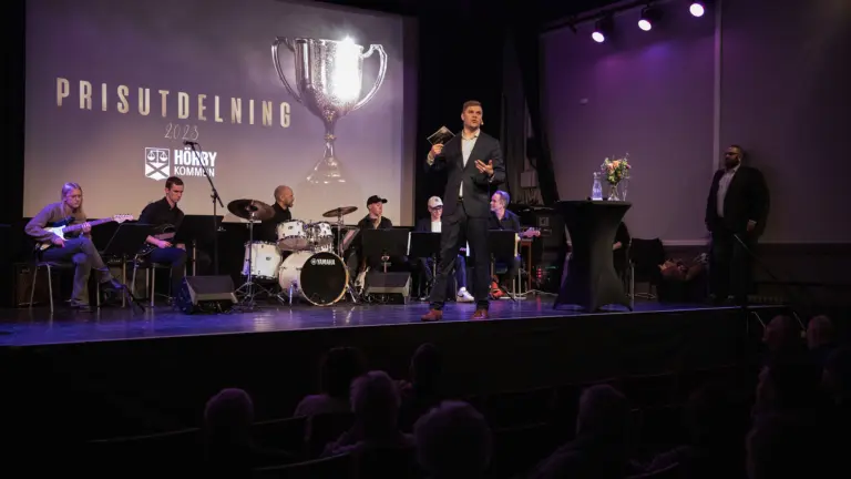 man står på scen och pratar i mikrofon på en prisutdelning