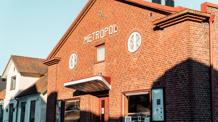 Röd tegelbyggnad med vita bokstäver METROPOL