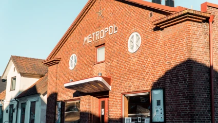 Röd tegelbyggnad med vita bokstäver METROPOL