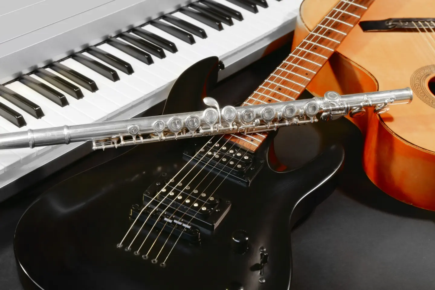 En närbild på piano, flöjt och gitarr