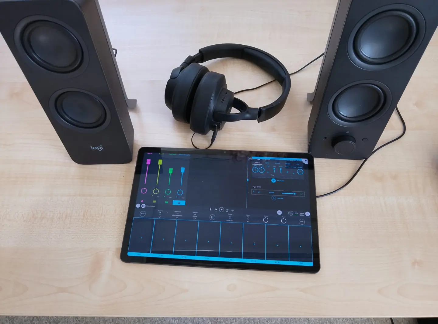 högtalare, headset och en iPad med ett digitalt mixerbord på skärmen