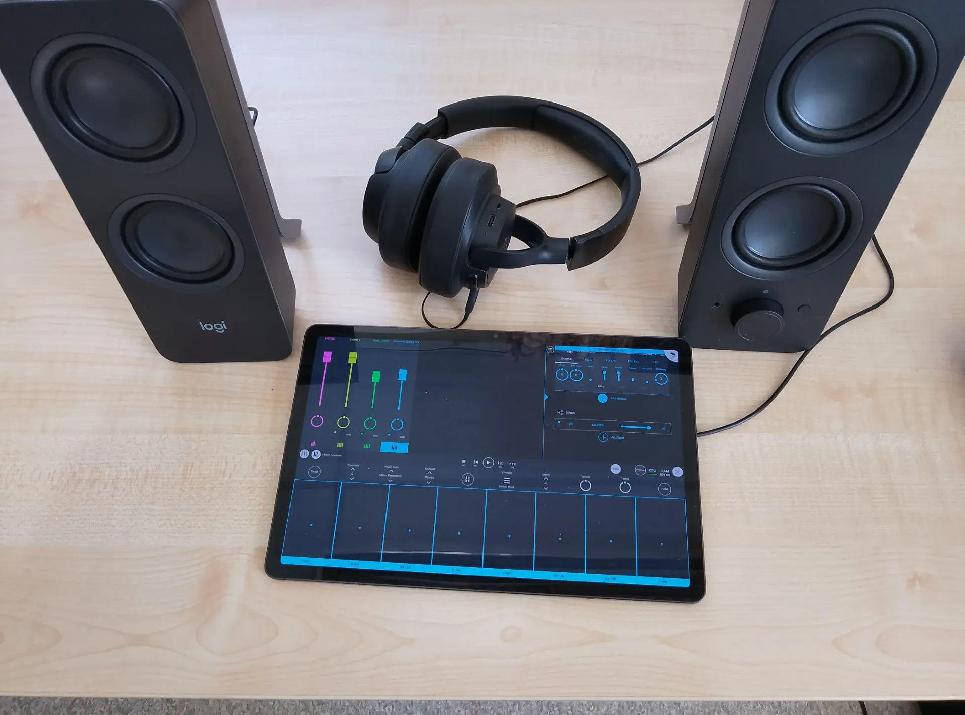 högtalare, headset och en iPad med ett digitalt mixerbord på skärmen